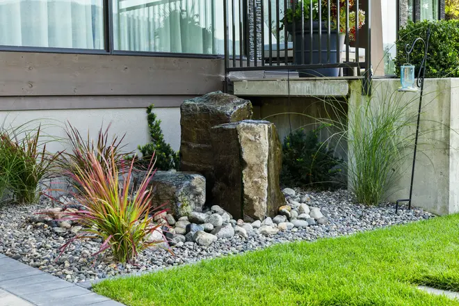 Rock water feature with softscaping by Empire Landscaping.
